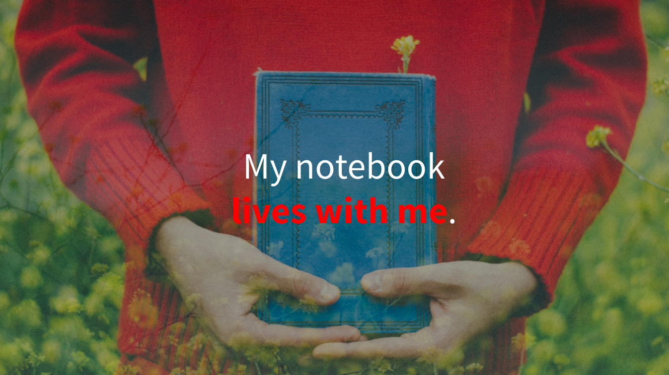 Man in red sweater holding a notebook with overlaid text saying "My notebook lives with me."